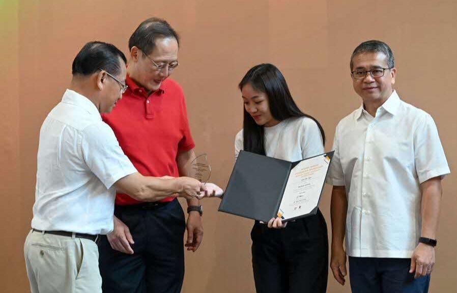 Sin Yee receiving her award plaque at the award ceremony